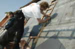 Zwei Dachdecker arbeiten auf dem Dach eines Hauses