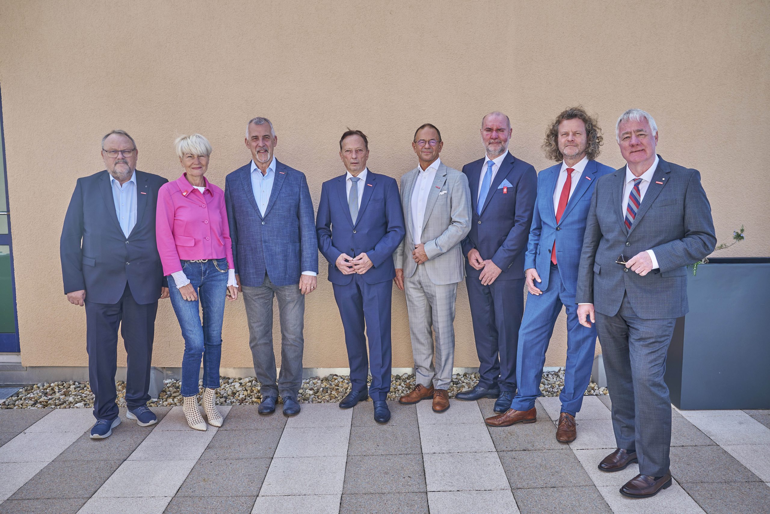 Gruppenfoto von acht Präsidentinnen und Präsidenten ostdeutscher Handwerkskammern vor einer Gebäudewand.