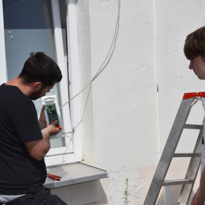 Bevor es mit der praktischen Installation losgehen kann, erklärt Martin Bolduan (l.) Schüler Malte die Funktionsweise einer Alarmanlage.