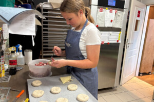 Johanna bereitet Schinken-Käse-Brötchen vor.