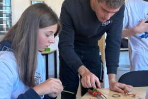 Lori mit Azubi Philo Palm. Die Schülerin Lori findet den Beruf Elektroniker generell interessant und möchte gerne wissen, wie genau Elektronik funktioniert.